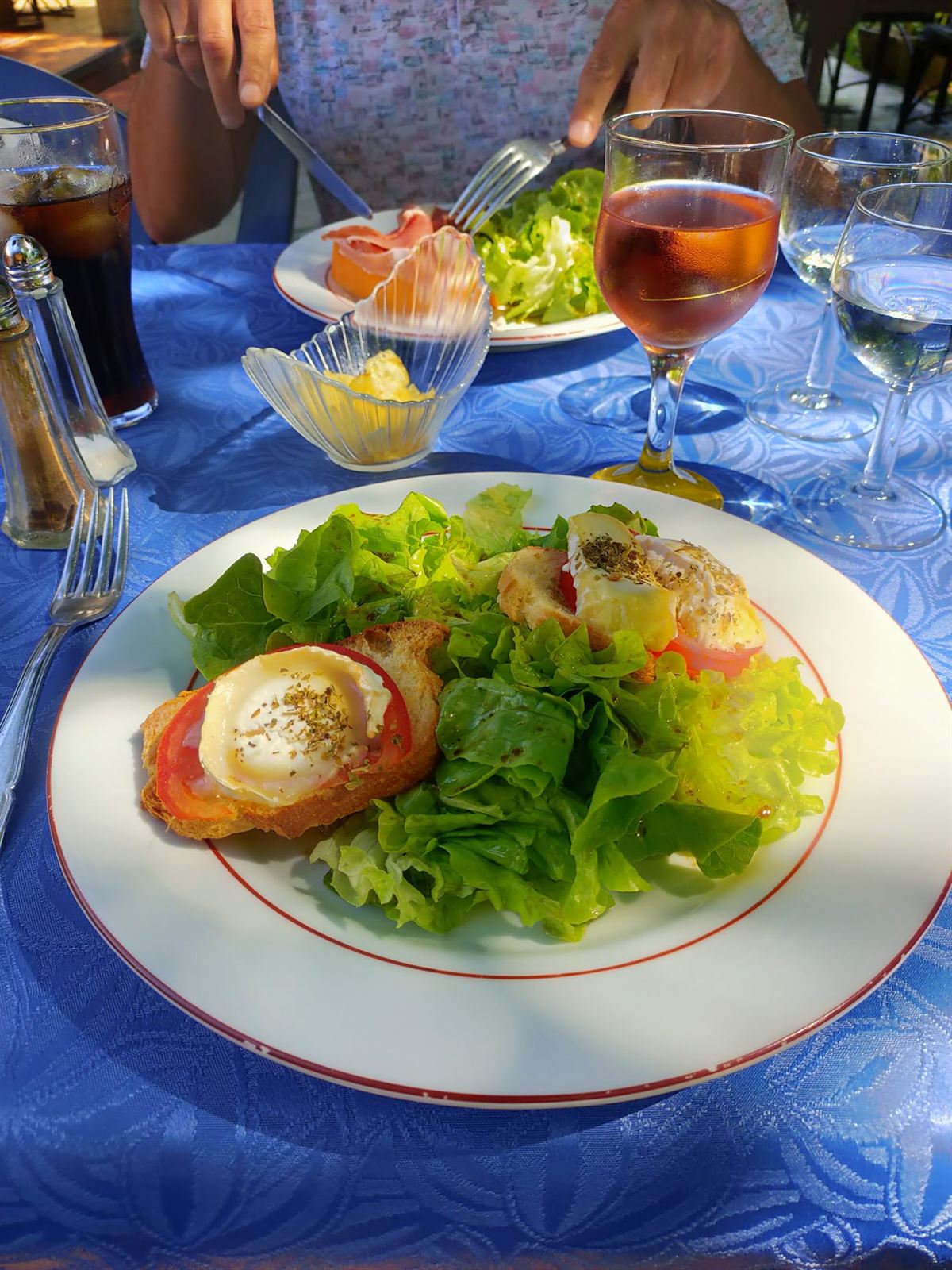 Salade fraîche au chèvre chaud servie sur une nappe bleue